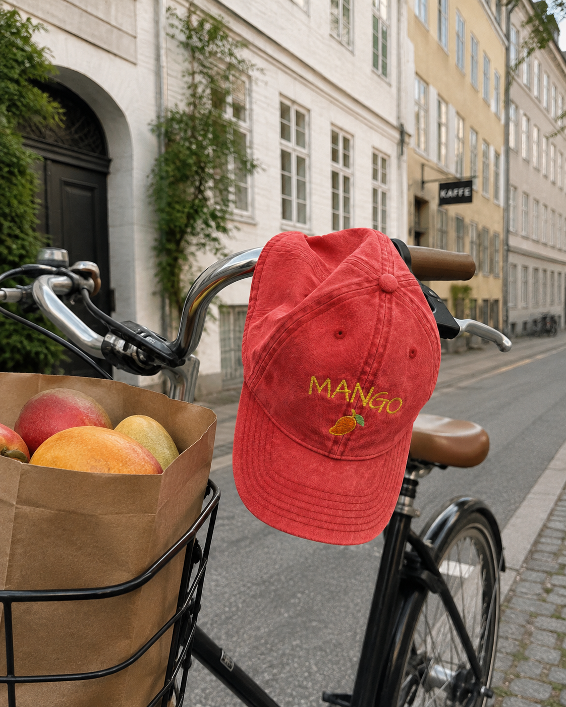 Red Mango cap hanging from a bicycle with mangos in the basket