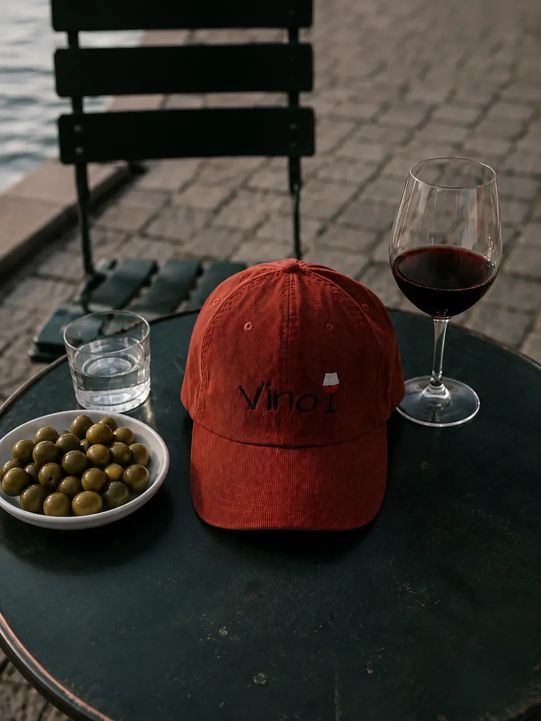 Vino cap on a table with a glass of red wine and olives